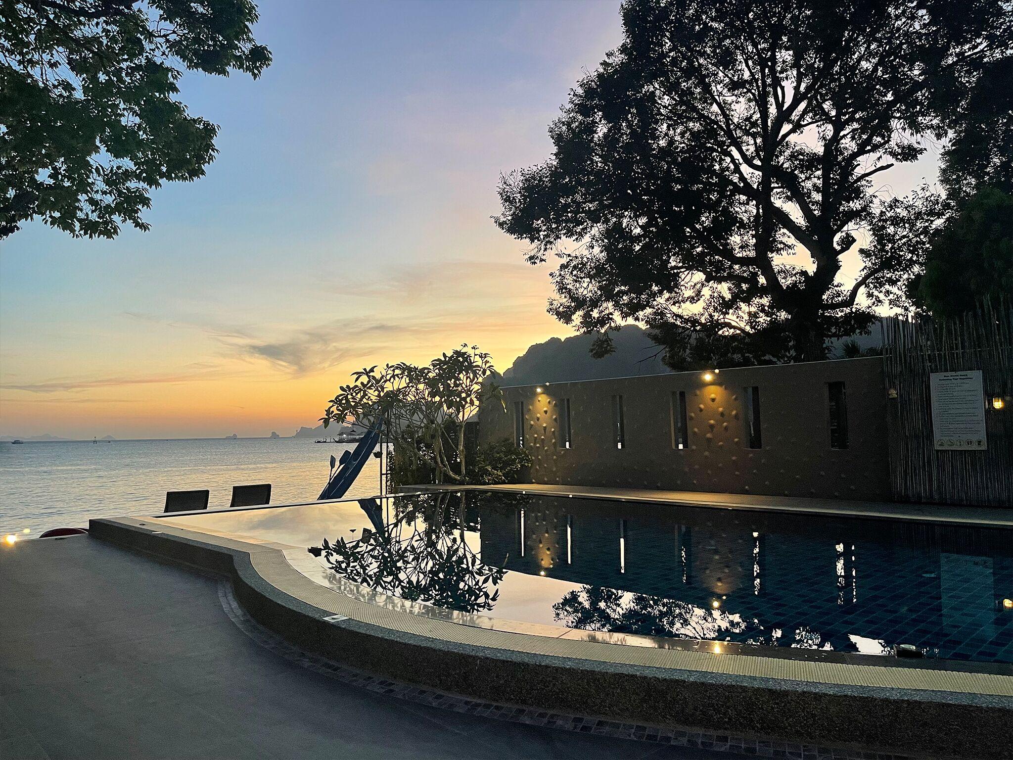 Dusk pool with a lit feature wall and reflections