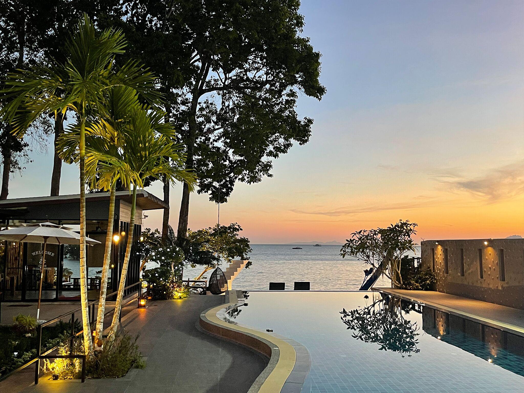 Golden-hour infinity pool fringed with palms