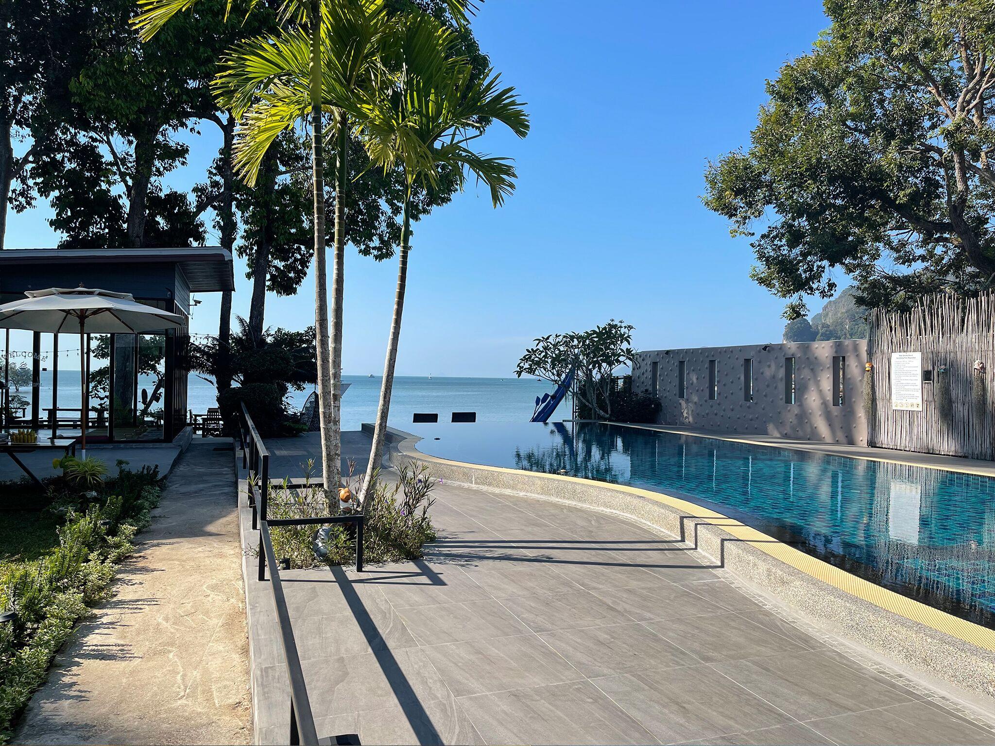Palm-lined pool walkway to the sea
