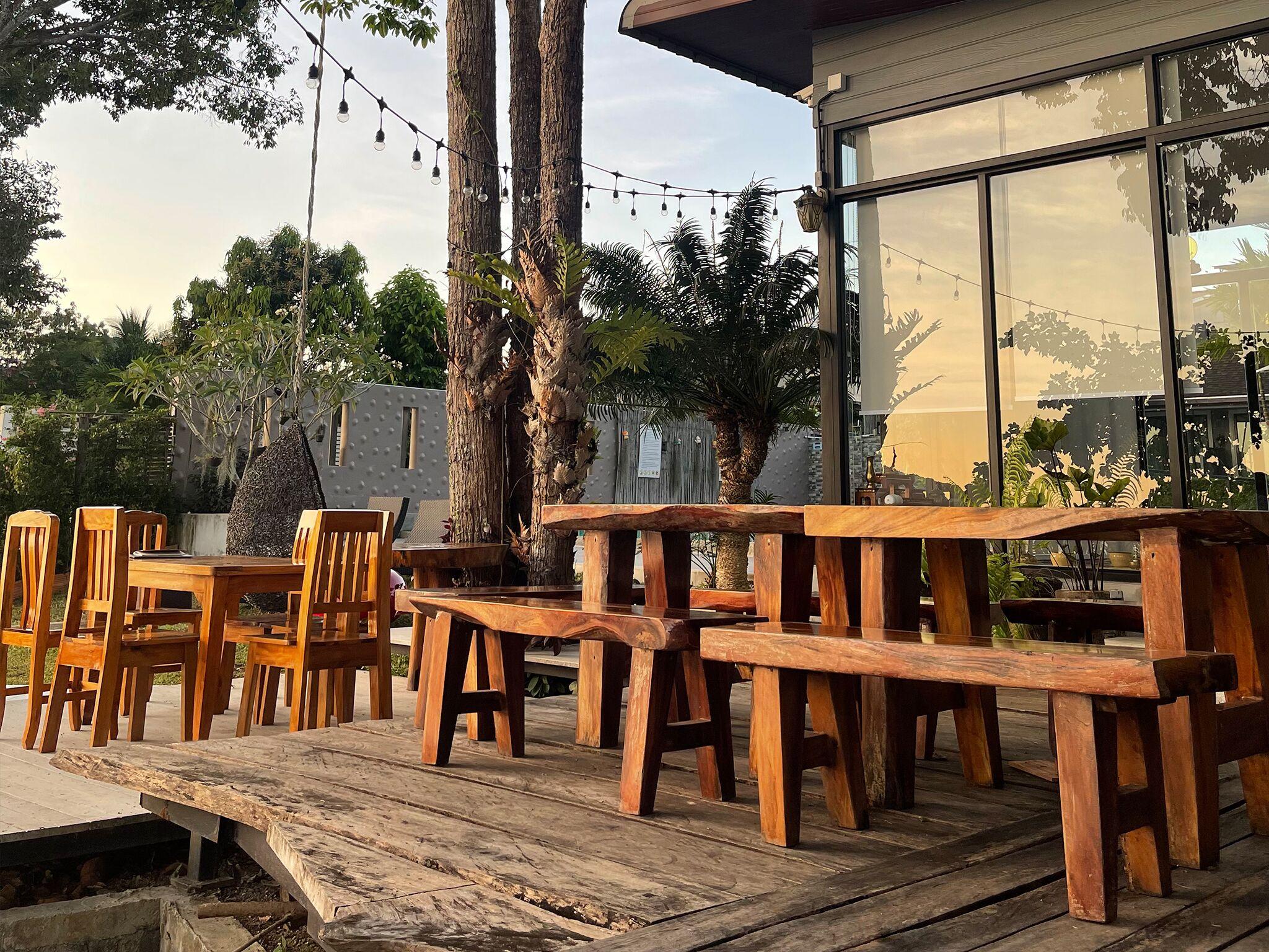 Live-edge wood dining deck strung with warm lights at golden hour